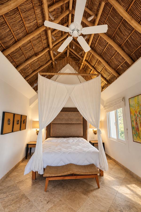 Cama con mosquitero bajo la palapa